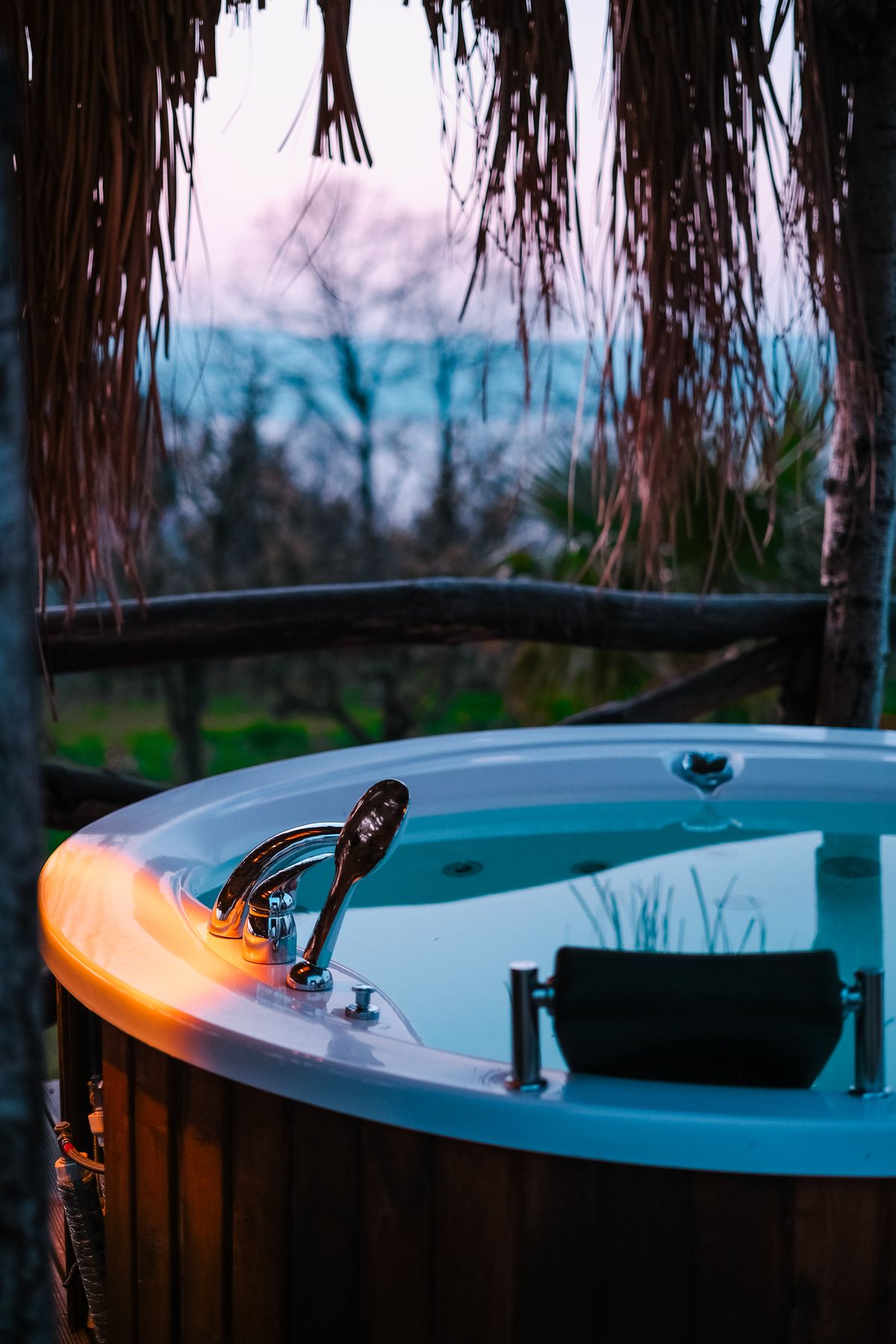 Zapuštěné spa s vodou v zahradě za soumraku