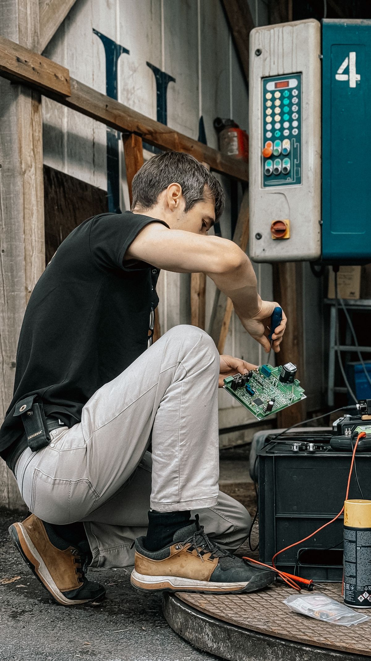 Technik s nářadím opravuje elektronickou řídicí desku technologie