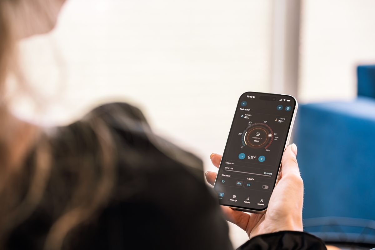 Žena nastavuje teplotu wellness zařízení v mobilní aplikaci