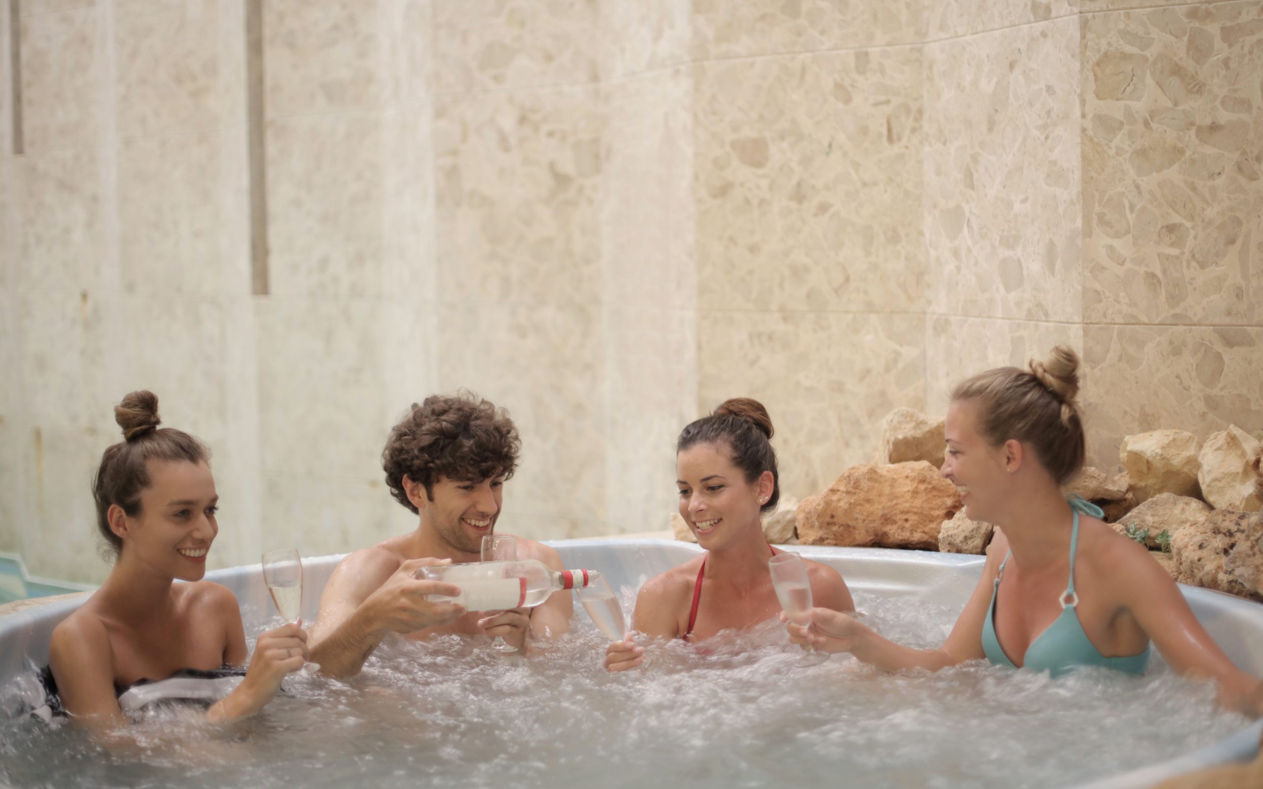 Přátelé odpočívají společně ve vířivce, domácí wellness ve dvou i více lidech