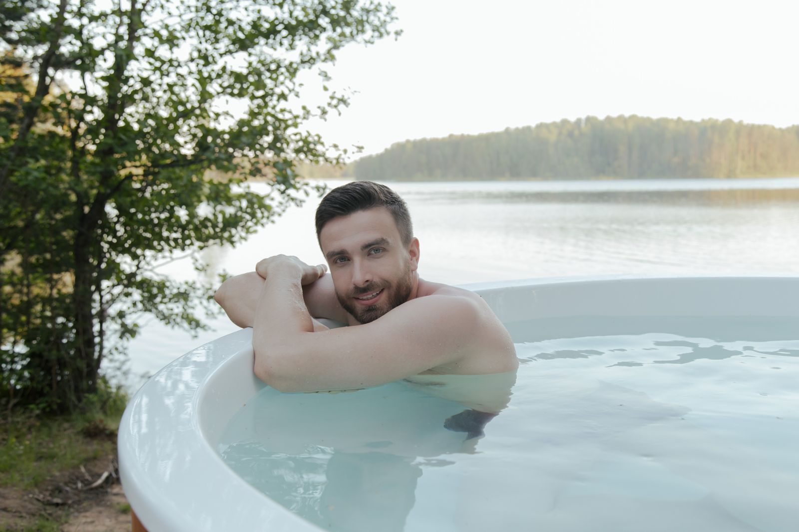 Muž odpočívající na okraji vířivky po dokončené hydromasáži