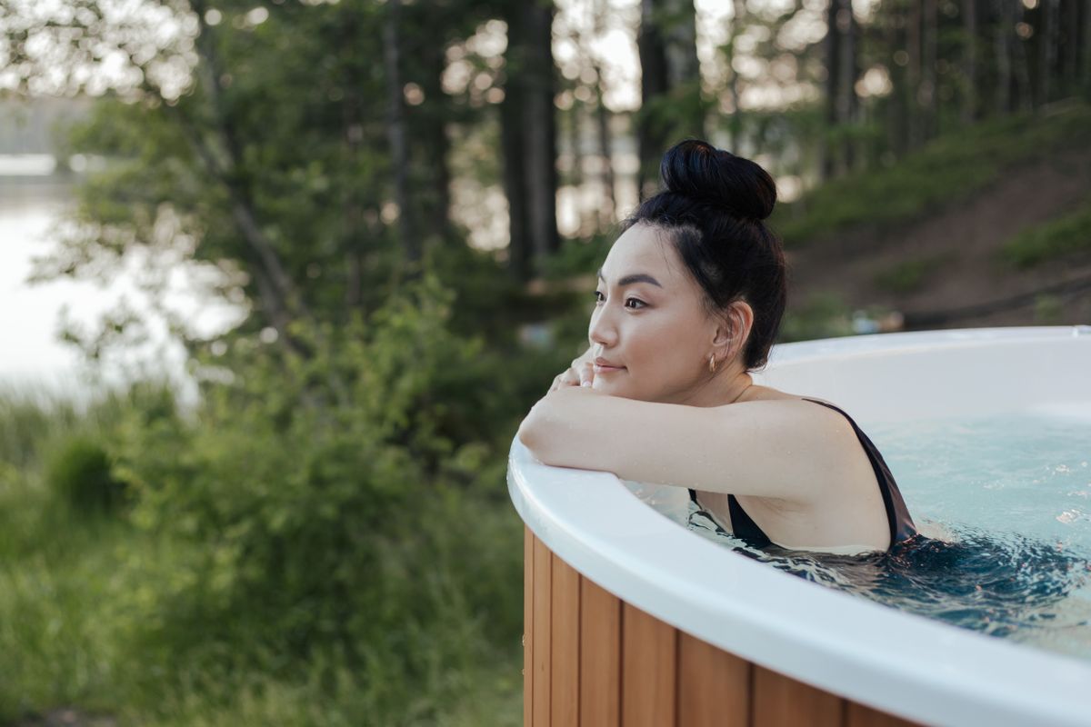 Žena relaxující v kompaktní vířivce s dřevěným opláštěním
