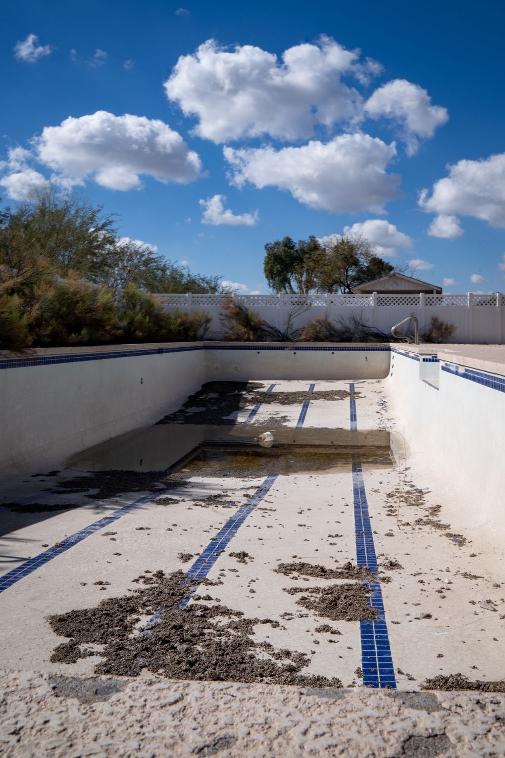 Starý zanedbaný betonový bazén s poškozeným povrchem před renovací