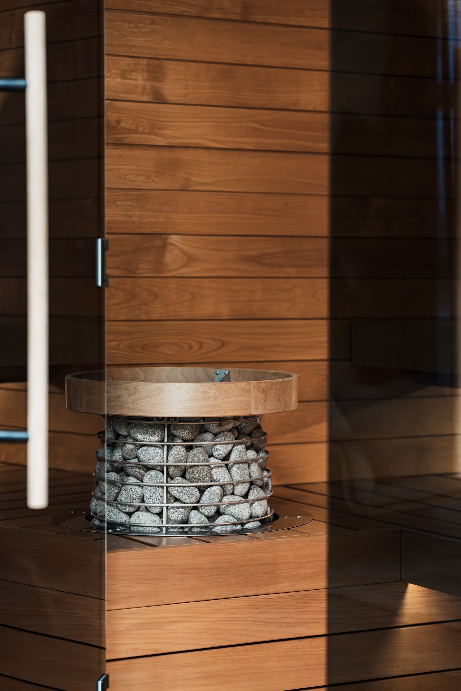 Moderní finská sauna s dřevěným obkladem a kamny plněnými kameny
