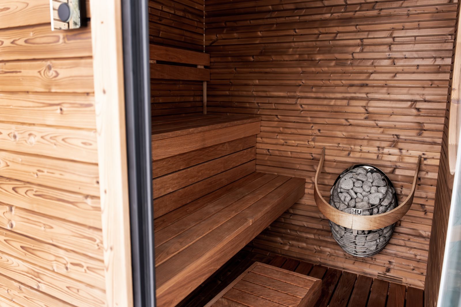 Dřevěná domácí sauna s elektrickými kamny a lavicemi