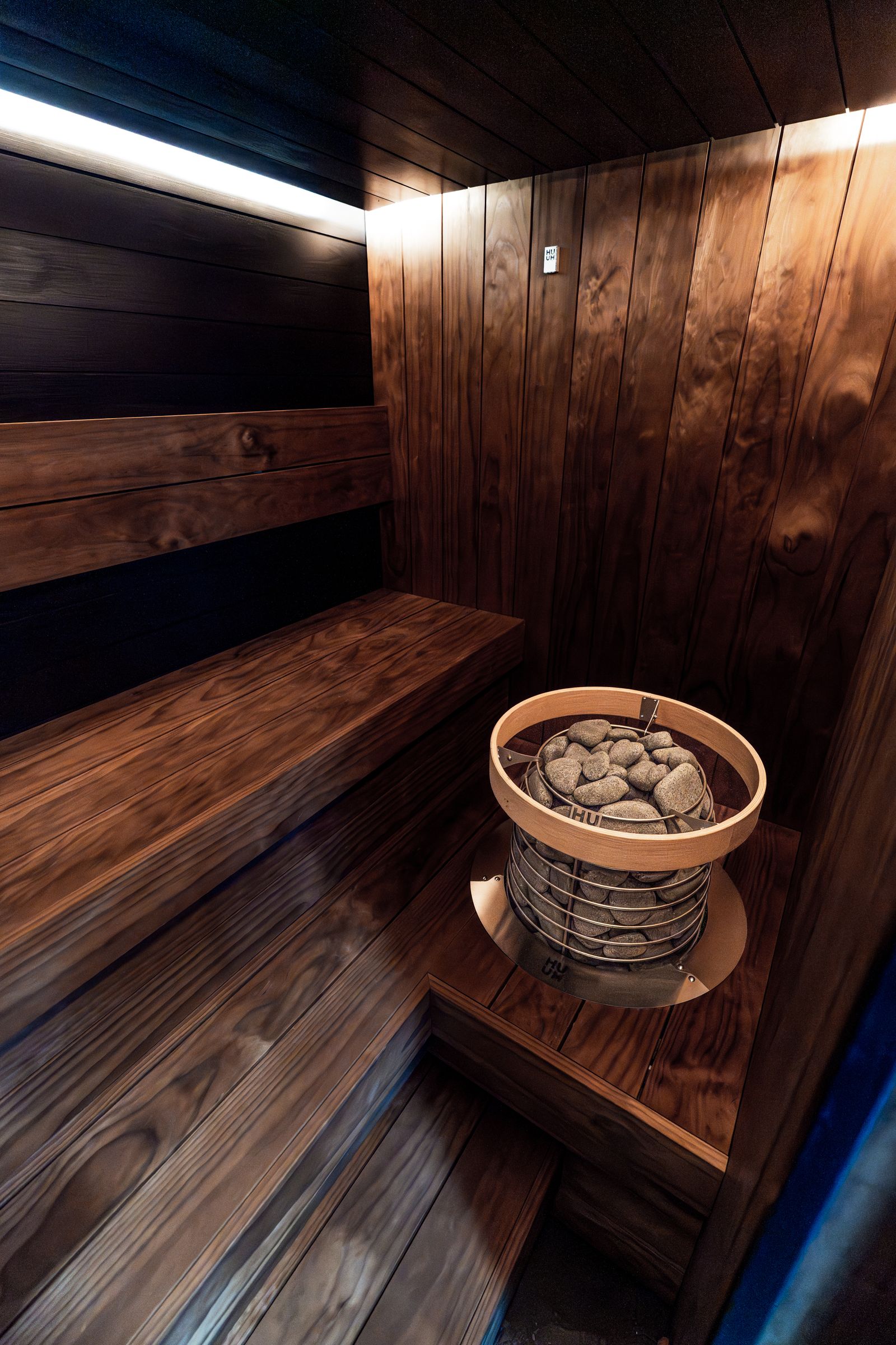 Moderní sauna s elektrickými kamny naplněnými saunovými kameny