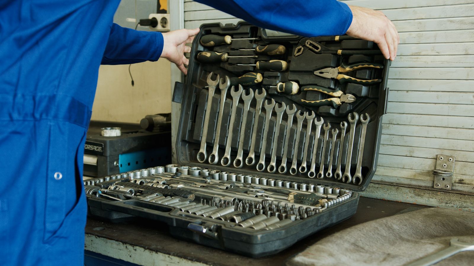 Servisní technik otevírá kufr s nářadím pro opravu technologie